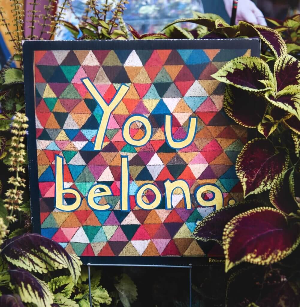 colorful tapestry with the words "you Belong" suggrounded by colorful foliage