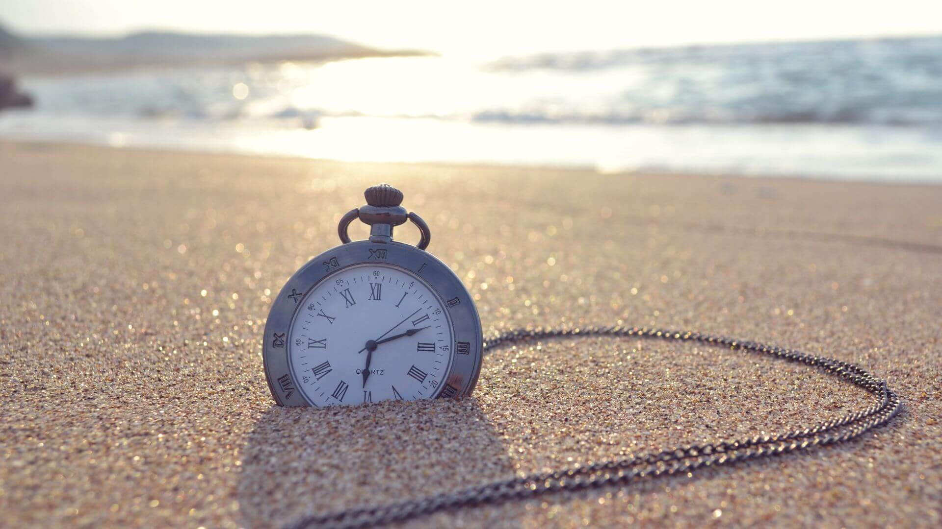 pocket watch set on a sandy beach