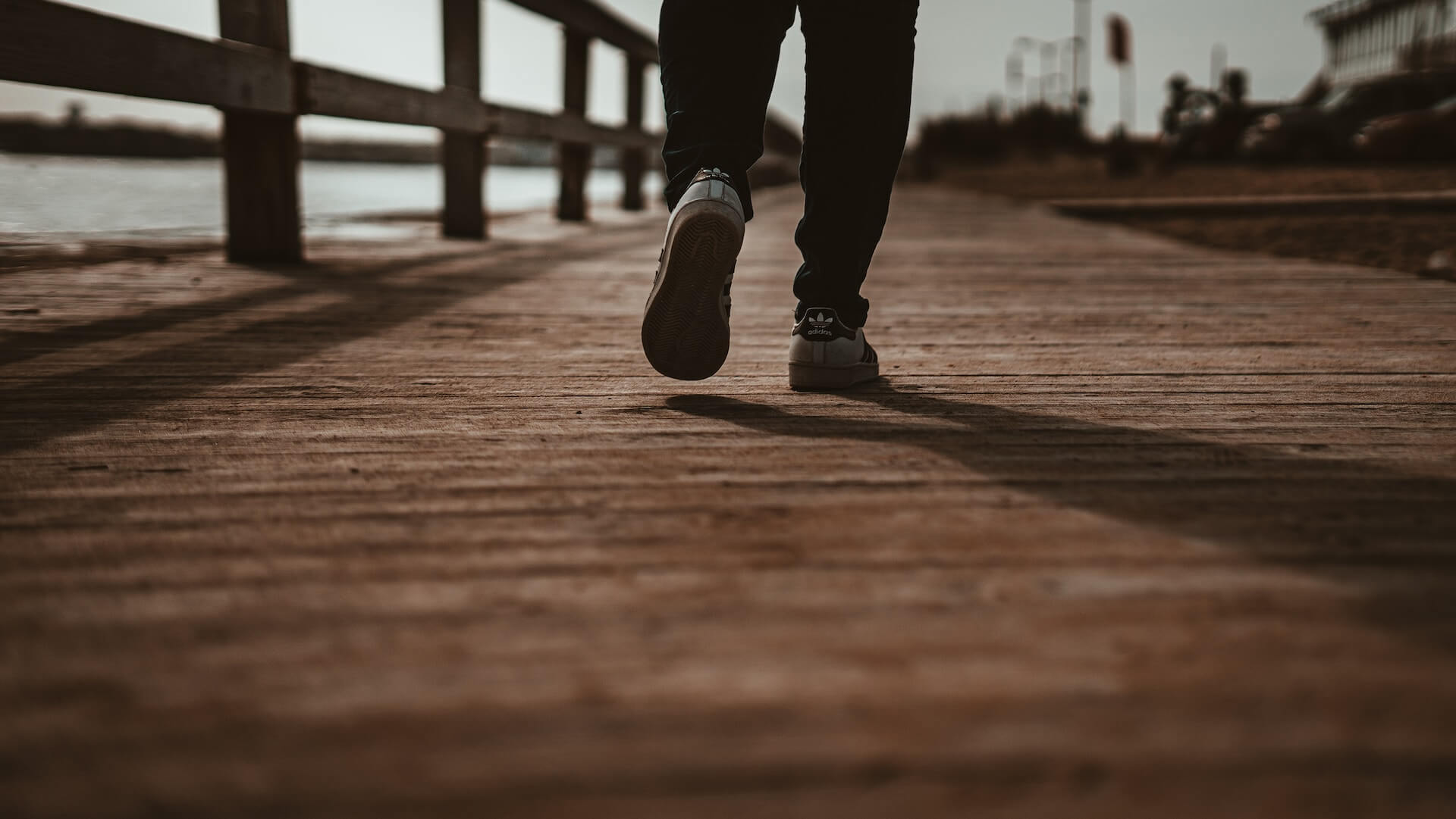 legs and feet walking away on boardwalk - photo