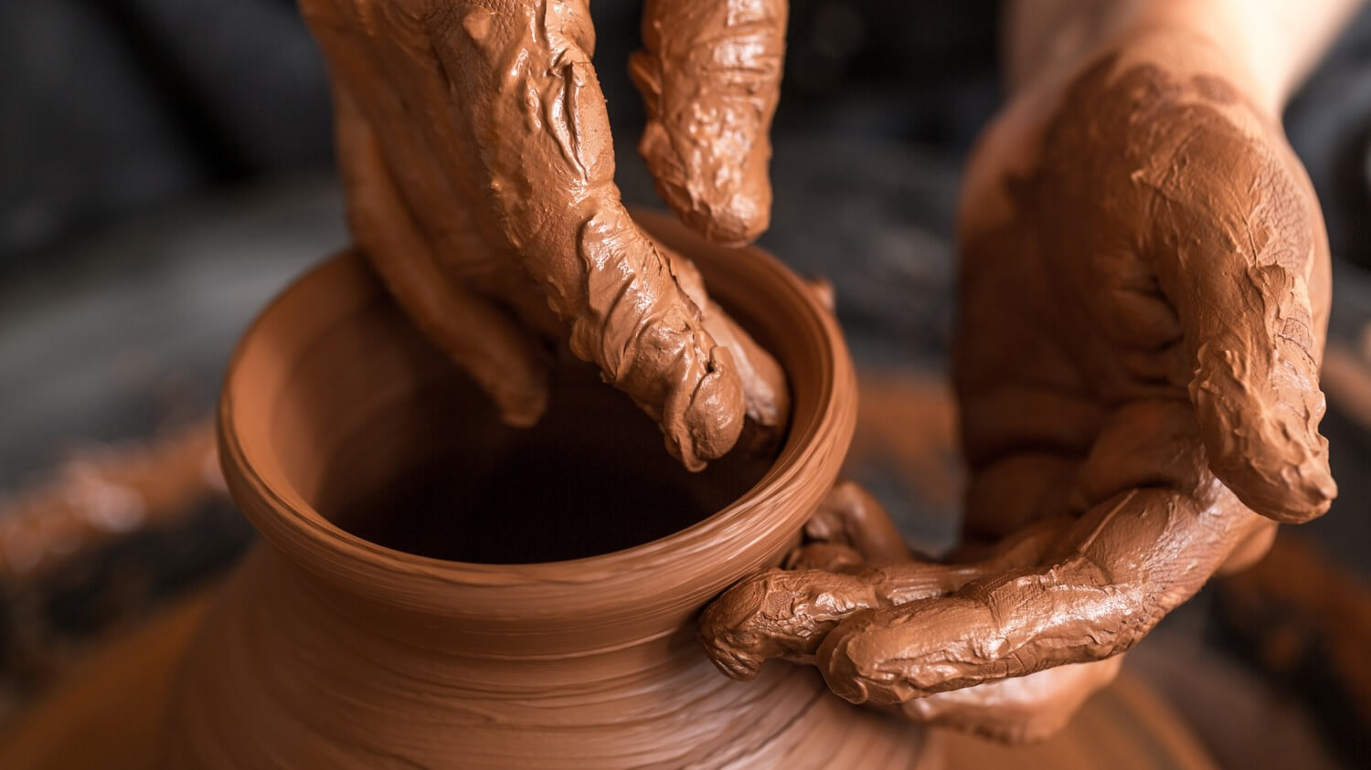 hands molding clay on a potters wheel - photo