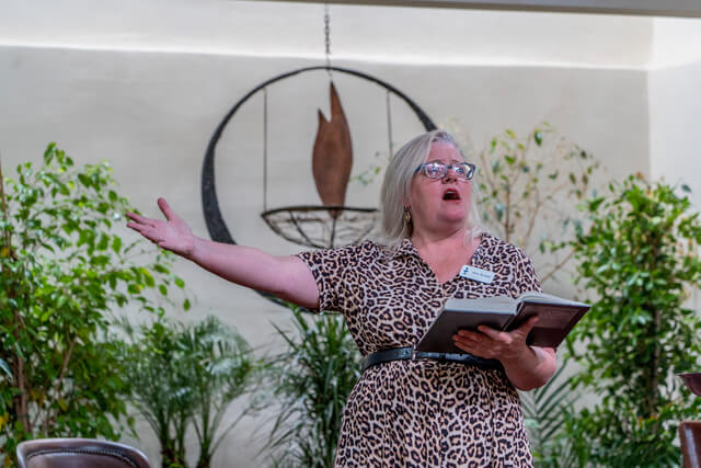Amy Brunell 2023 singing, with hymnal