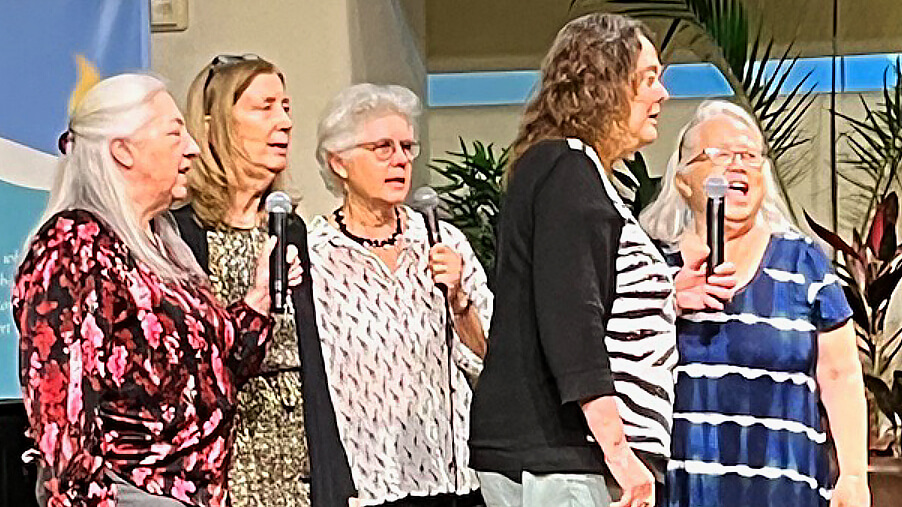 Five women singing "I Am Woman"
